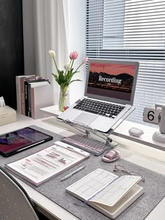 a laptop computer sitting on top of a desk next to a phone and other items