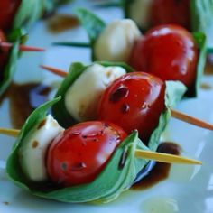 small appetizers with tomatoes and cheese on toothpicks are ready to be eaten