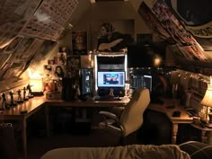 a desk with a computer on top of it in a room filled with posters and lights