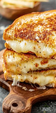 two grilled cheese sandwiches stacked on top of each other with parmesan cheese