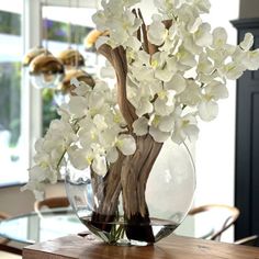 a vase filled with white flowers on top of a wooden table