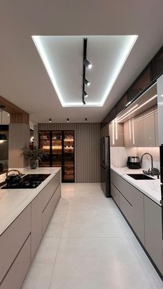 a modern kitchen with white counter tops and stainless steel appliances, along with recessed lighting