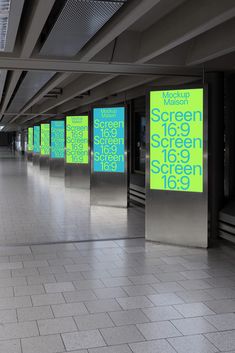 an empty subway station with green and blue signs