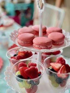 three tiered trays filled with pastries and berries on top of each other