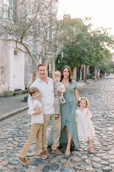 a family posing for a photo on the cobblestone street