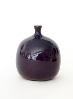 a purple vase sitting on top of a white table