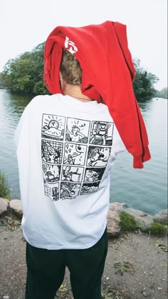 a man wearing a red bandana over his head looking at the water and land