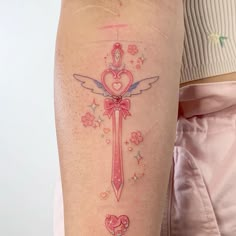 a woman's arm with a cross and heart tattoo on the left side of her leg