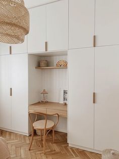 a bedroom with white cupboards and wooden flooring