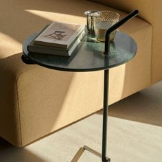 a glass table with a book on it next to a couch