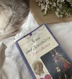 a book sitting on top of a bed next to flowers