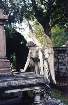 an angel statue sitting on top of a stone bench