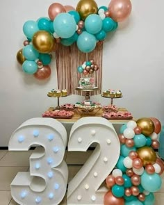 a decorated table with balloons, cake and number twenty five on the top shelf in front of it