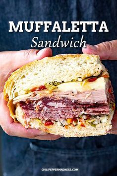 a person holding a sandwich in their hands with the words muffafetta sandwich on it