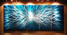 an abstract painting in blue and white with lights on the wall behind it is a large piece