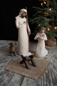 a nativity scene with two figurines and a christmas tree