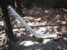 an inflatable tube is attached to a tree near a fence and some leaves