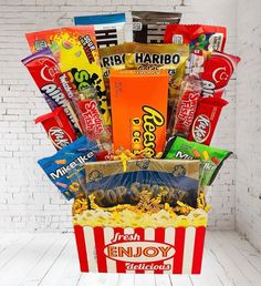 This candy bouquet is designed to look like a popcorn bucket, making it a fun and festive centerpiece for your movie night. It's also a fantastic gift for movie lovers, birthdays, or any occasion that calls for a sweet celebration. | Transform any movie night into an unforgettable experience with our Movie Night Candy Bouquet! Perfect for family gatherings, date nights, or a solo film fest, this candy bouquet is brimming with all the sweet and savory treats you love from the theater. Each bouquet is thoughtfully arranged to capture the magic of a classic movie night. | 1-800-Flowers Everyday Gift Delivery Movie Night Candy Bouquet Movie Night Candy, Movie Theater Candy, Movie Basket, Candy Bar Bouquet, Candy Bar Cake, Fathers Day Gift Basket, Candy Arrangements, Valentine's Day Gift Baskets, Food Gift Baskets