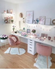 a white desk with pink chairs and pictures on the wall above it in a bedroom