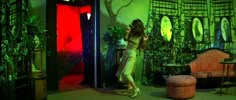 a woman is walking through a room with green walls