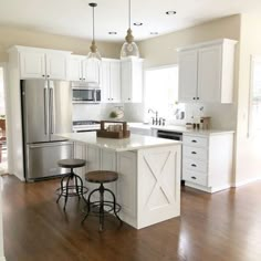 a kitchen with white cabinets and wooden floors