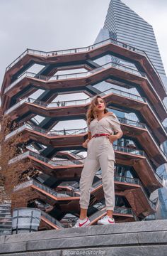 a woman standing in front of a tall building