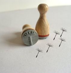 a rubber stamp sitting on top of a piece of paper next to some dandelions