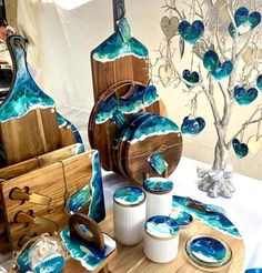 a table topped with plates and bowls covered in blue art glass paint next to a tree