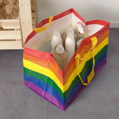 a rainbow colored shopping bag with bottles in it