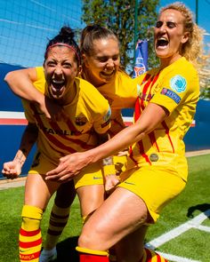 two women in yellow soccer uniforms are on the field with their arms around each other