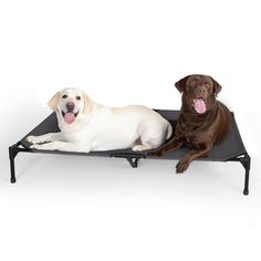 two dogs are laying down on a dog bed with their tongue out and one is panting