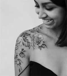 a woman with a flower tattoo on her chest and shoulder is smiling at the camera