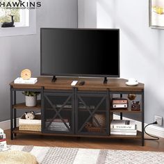 a flat screen tv sitting on top of a wooden entertainment center in a living room