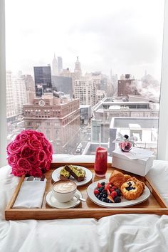 a tray with food on top of it in front of a window overlooking the city