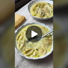 two white bowls filled with soup on top of a table