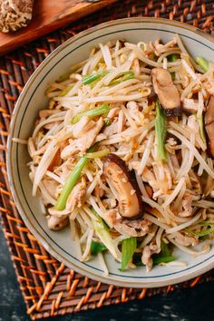 a white plate topped with noodles and mushrooms