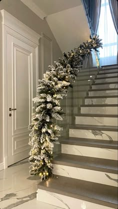 a christmas garland is hanging on the stairs