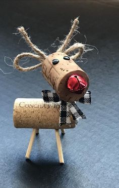 a wine cork reindeer with a red nose and black bow on it's head