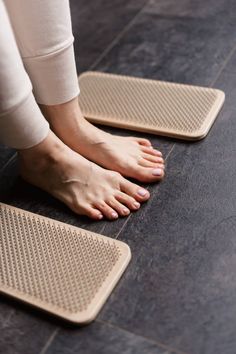 a woman standing on the floor with her feet propped up against two placemats