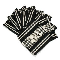 four black and white knitted coasters on top of each other, with an image of a cat in the middle