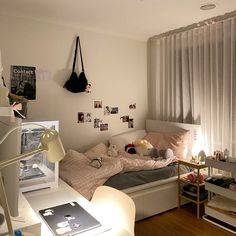 a bedroom with a bed, desk and computer monitor on the wall next to it