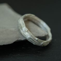 a silver ring sitting on top of a piece of paper next to a cloth bag