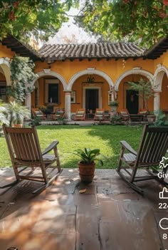 two wooden chairs sitting in front of a yellow house