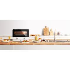 a stove top oven sitting on top of a wooden counter next to a bowl of food