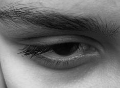 a close up view of the eye of a man with long black hair on his head