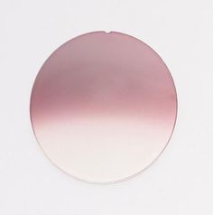 a pink and white circular object sitting on top of a white surface with no one around it