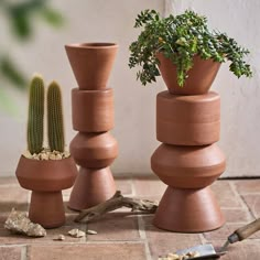 three clay pots are stacked on top of each other with a cactus in the middle