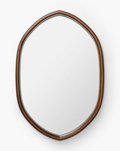 a round mirror on the wall with a wooden frame and brown leather band around it