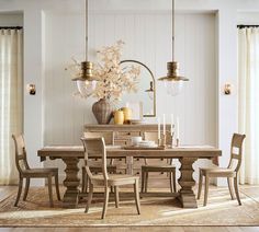 a dining room table with chairs and a vase filled with flowers on top of it