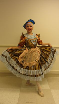 a woman is dressed in an old fashion dress and holding a bird on her shoulder